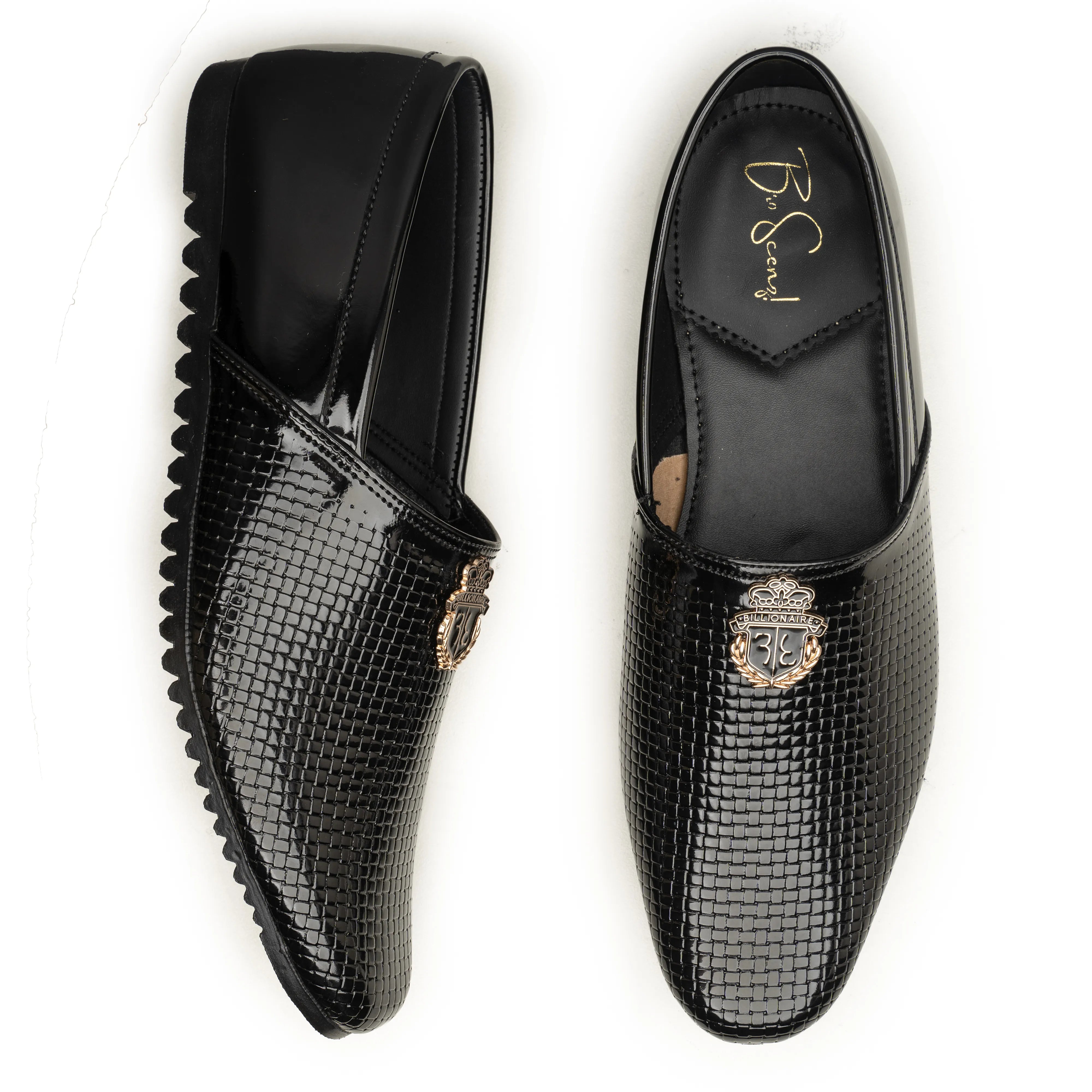 A pair of black leather loafers with a crocodile-embossed texture, one shown from a side profile and the other from a top-down view. Both feature a polished gold-tone shield logo on the toe area and a black elastic heel loop.