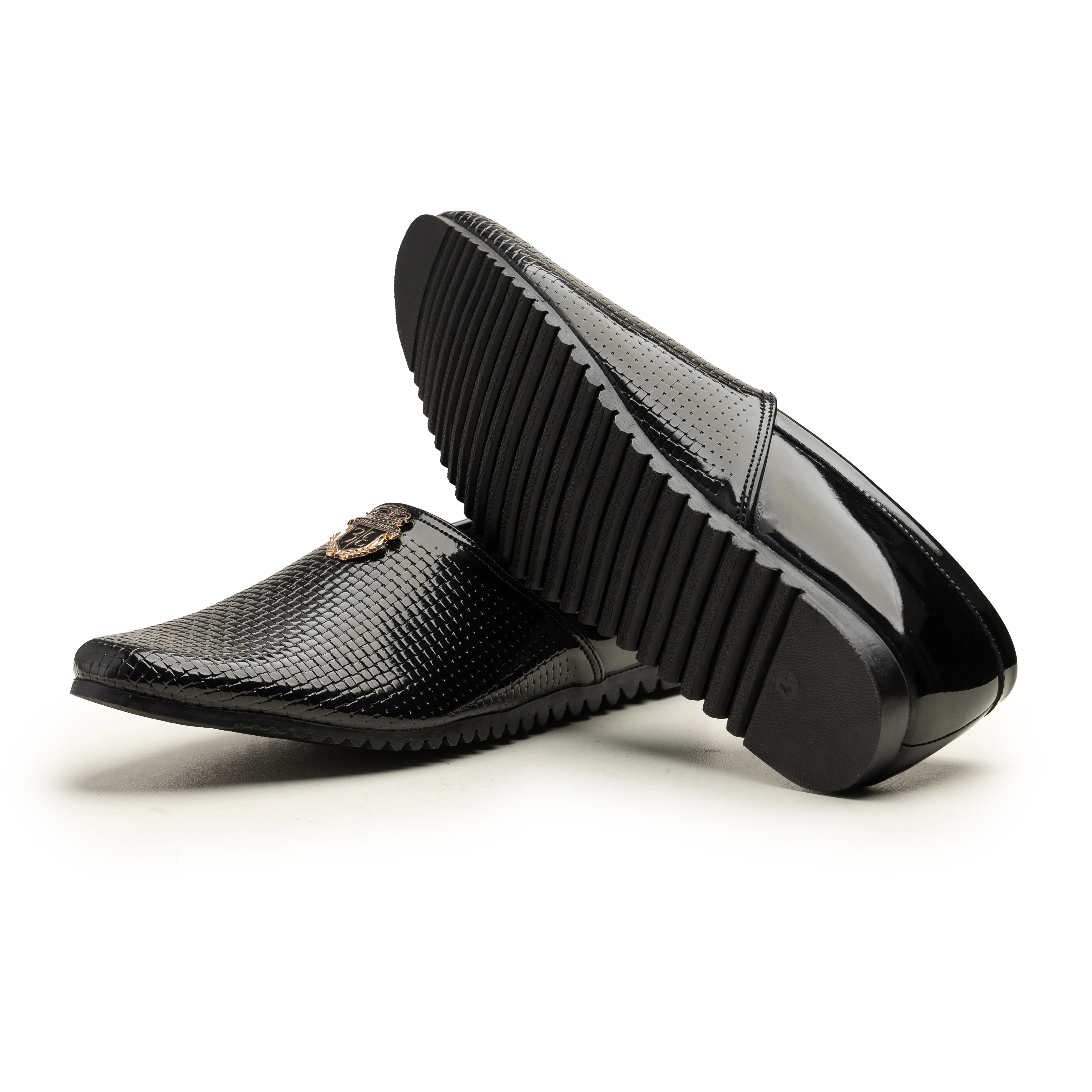 A pair of men's black slip-on loafers, one shown from the side with a textured black upper and a small gold-tone logo detail, and the other showing the glossy black ribbed sole, set against a plain white background.