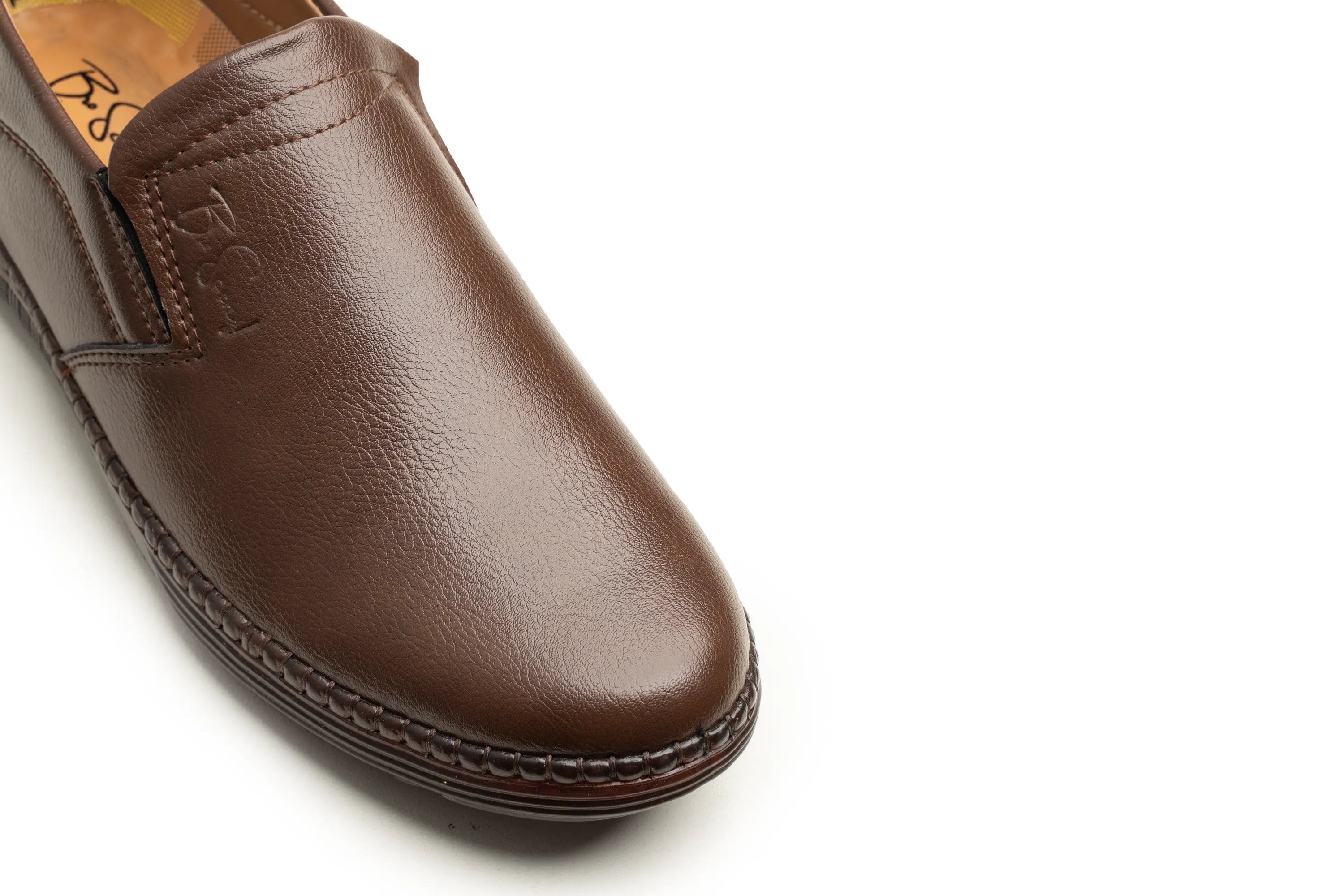 A close-up of a brown leather slip-on loafer shoe, showing the textured leather upper, stitched side, and dark sole against a plain white background.